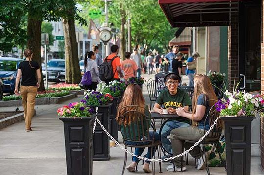 Students sitting outside at a downtown Saratoga Springs cafe